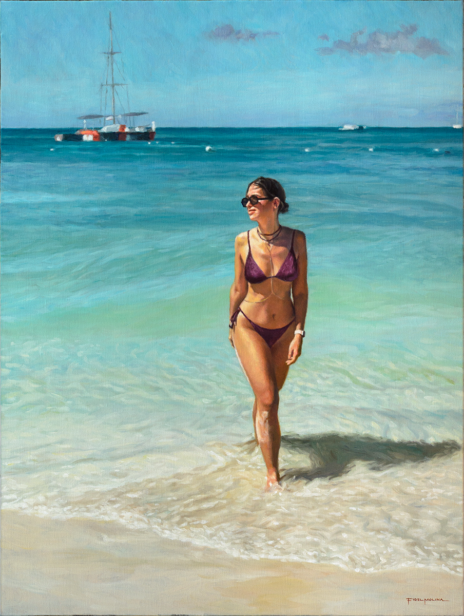 Mujer joven con bikini, gafas de sol y cadenas paseando por la orilla del mar con un barco al fondo.